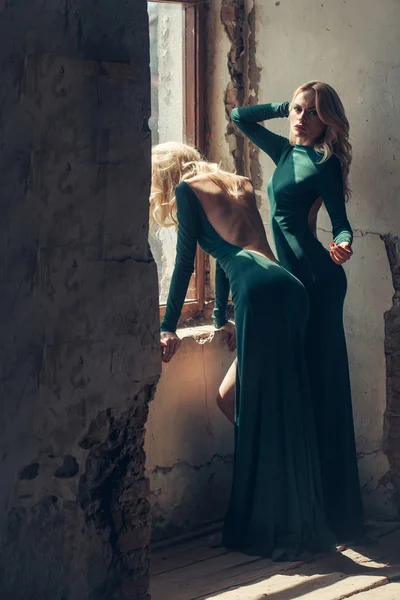 Mulheres bonitas em vestidos verdes perto da janela — Fotografia de Stock