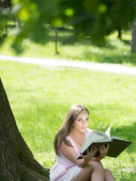 Güzel kadınla çimenlerin üzerinde kitap okuma — Stok fotoğraf