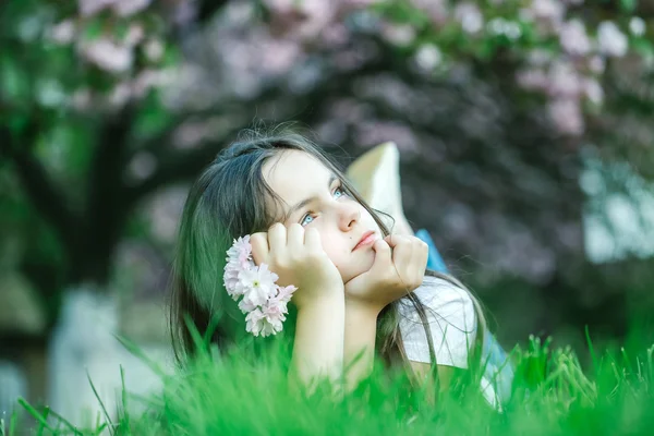 Kislány a füvet a virágzás — Stock Fotó
