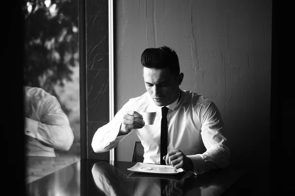 Young man drinks coffee — Stock Photo, Image