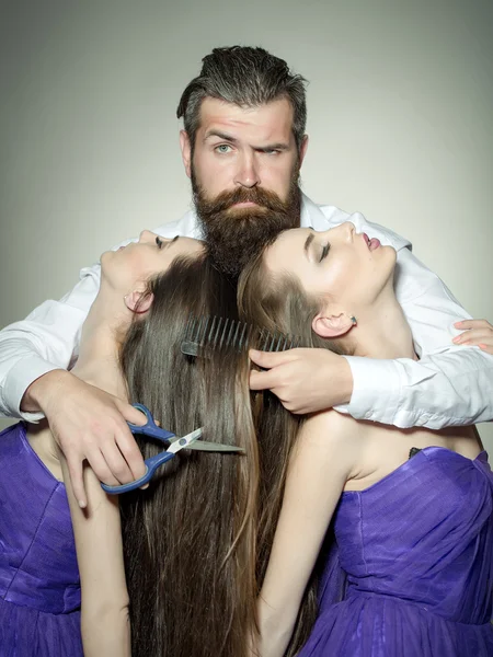 Cabeleireiro barbudo e duas mulheres — Fotografia de Stock