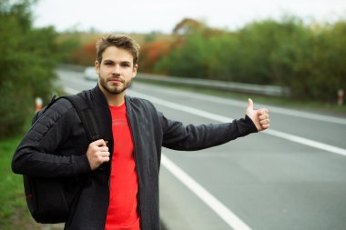 Genç adam otostop çekiyor.