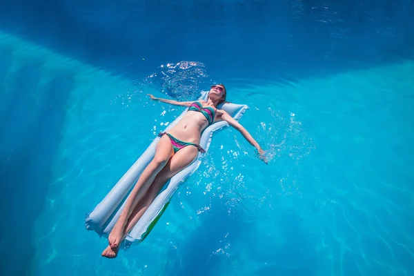 Jeune femme relaxante dans la piscine — Photo