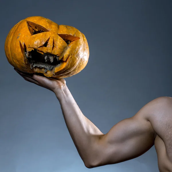 Mano masculina muscular con calabaza — Foto de Stock