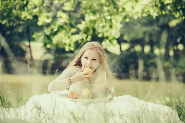 Liten tjej i klänning med fruktkorg — Stockfoto
