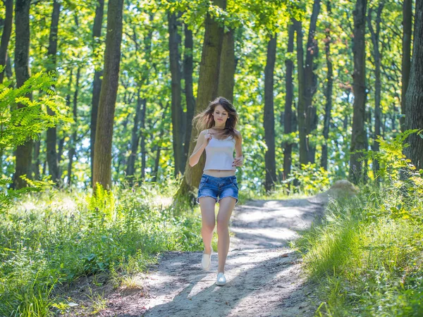 Jeune femme runnin dans la forêt — Photo