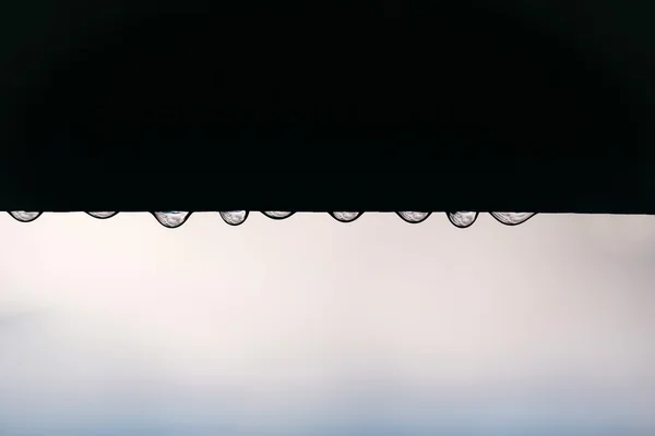 Kapać krople wody z dachu — Zdjęcie stockowe
