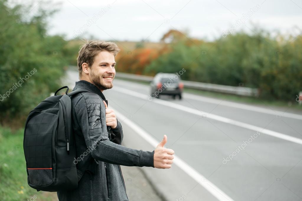 Young guy hitchhiking autostop