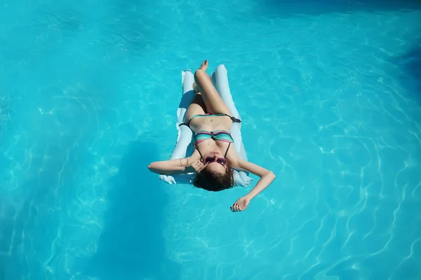 Mulher jovem relaxante na piscina — Fotografia de Stock