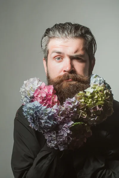 Homem barbudo com flores de hortênsia — Fotografia de Stock