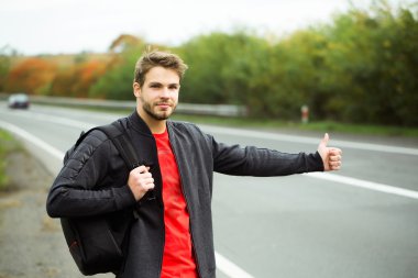 Genç adam otostop çekiyor.