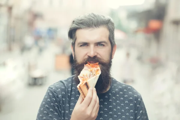 Knappe bebaarde man eten pizza — Stockfoto