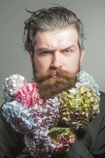 Homem barbudo com flores de hortênsia — Fotografia de Stock