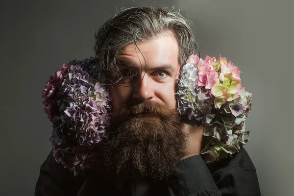 Homem barbudo com flores de hortênsia — Fotografia de Stock