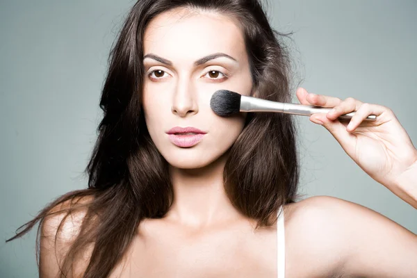 Vacker kvinna med makeup borste — Stockfoto