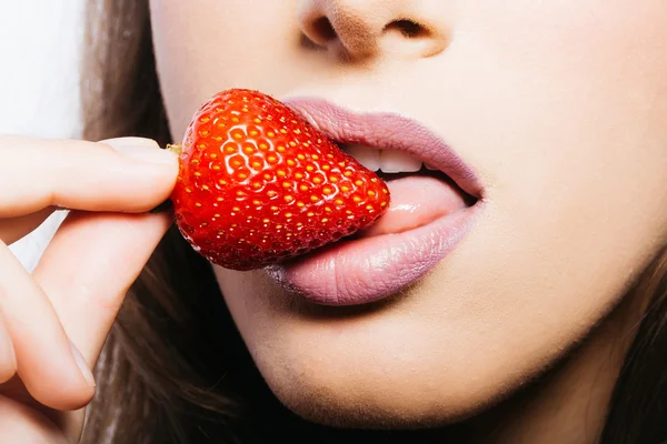 Labios femeninos comiendo fresa roja — Foto de Stock