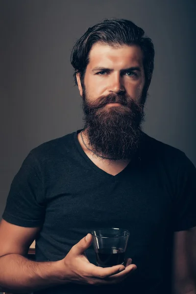 Vousatý muž se sklenkou brandy nebo whisky — Stock fotografie