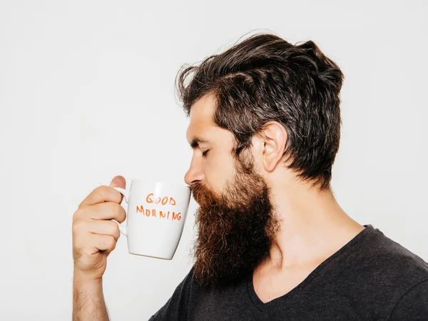 Бородатый серьезный человек с чашкой кофе или чая — стоковое фото