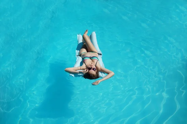 Jonge vrouw ontspannen in zwembad — Stockfoto
