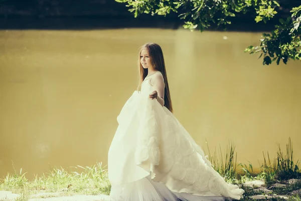 Маленькая девочка в белом платье на открытом воздухе — стоковое фото