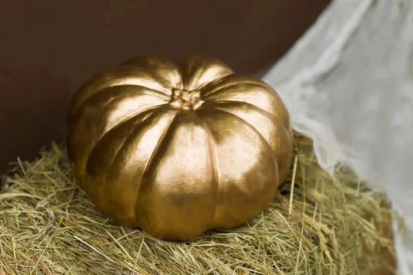 Abóbora de halloween dourada em pilha de palha Fotos De Bancos De Imagens