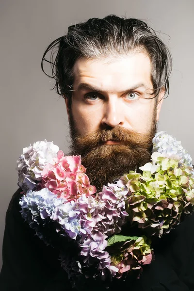 Homem barbudo com flores de hortênsia — Fotografia de Stock