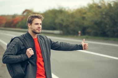 Genç adam otostop çekiyor.