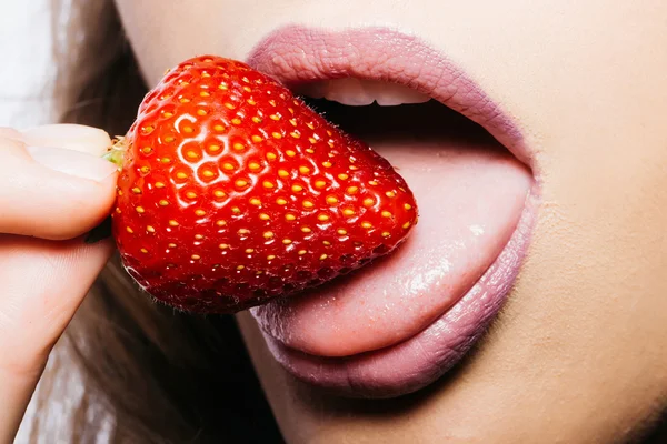 Labios femeninos comiendo fresa roja — Foto de Stock