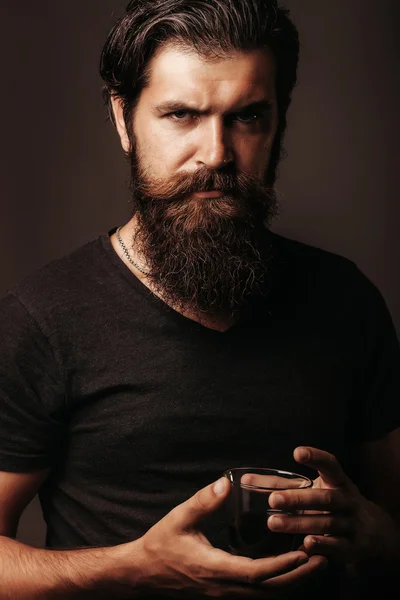 Homem barbudo com vidro de conhaque ou uísque — Fotografia de Stock