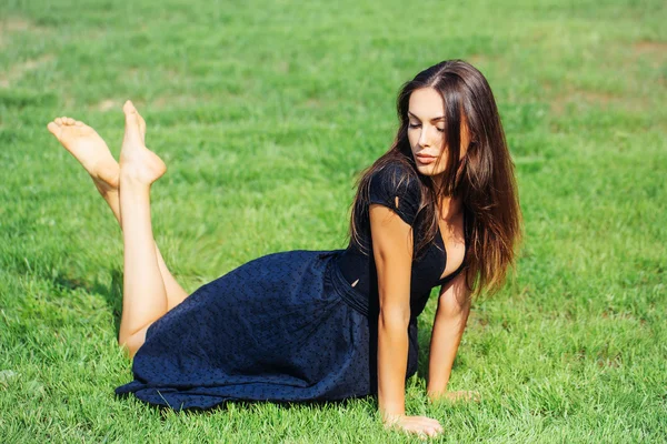 Young sexy woman laying on green grass — Stock Photo, Image