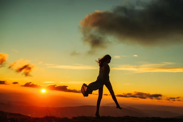 Mulher ao pôr-do-sol ou nascer do sol nas montanhas — Fotografia de Stock