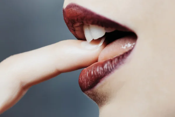 Женский рот с пальцем — стоковое фото
