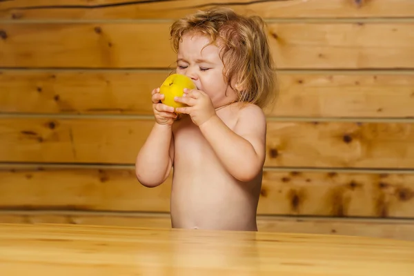 Bonito pequeno menino criança comer amarelo maçã — Fotografia de Stock