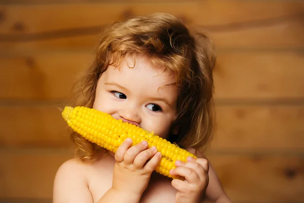 Engraçado menino pequeno criança comendo milho amarelo — Fotografia de Stock