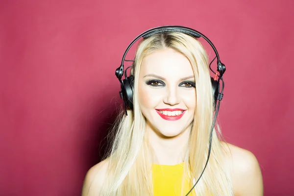 Bonita rubia dg chica en auriculares en rosa —  Fotos de Stock