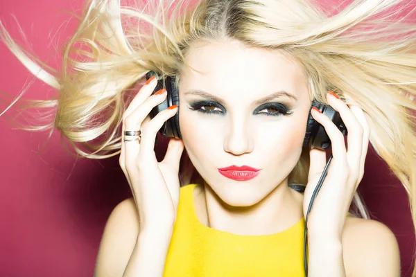 Vacker blond dj flicka i headsetet på pink — Stockfoto
