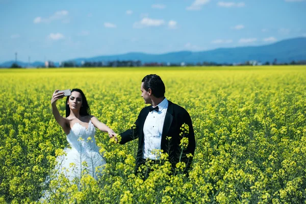 Couple de mariage dans le champ fleurs jaunes — Photo