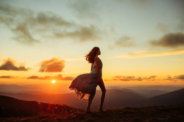 Mujer al atardecer o al amanecer en las montañas — Foto de Stock