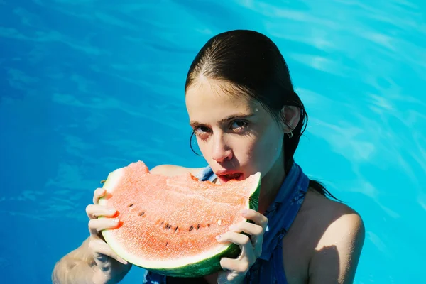 Женщина с арбузом в бассейне — стоковое фото