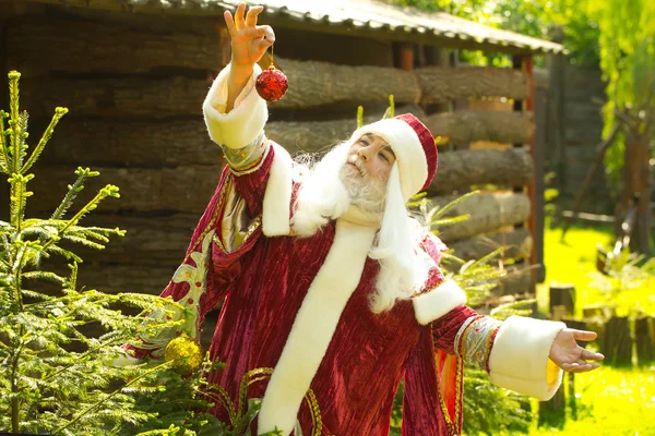 Santa claus díszíti a karácsonyfát — Stock Fotó