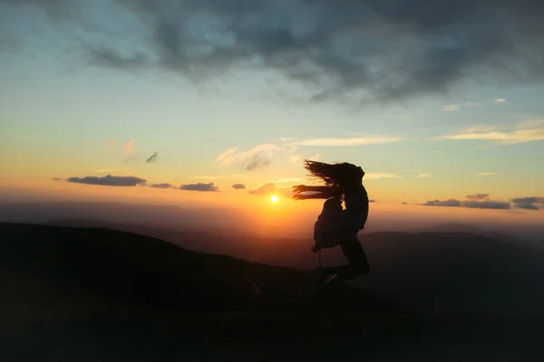 Kvinnan vid solnedgång eller soluppgång i bergen — Stockfoto