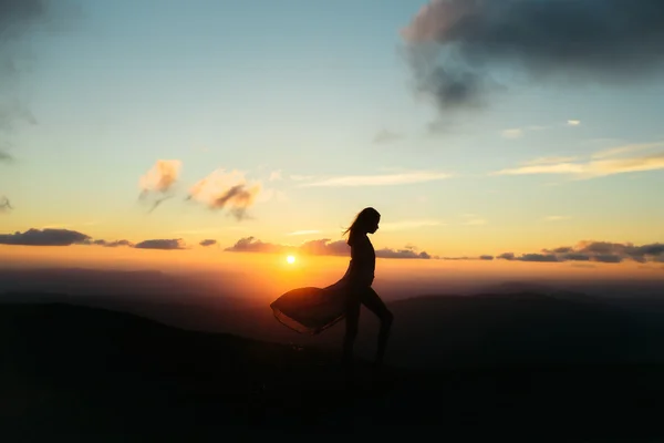 Mujer al atardecer o al amanecer en las montañas — Foto de Stock