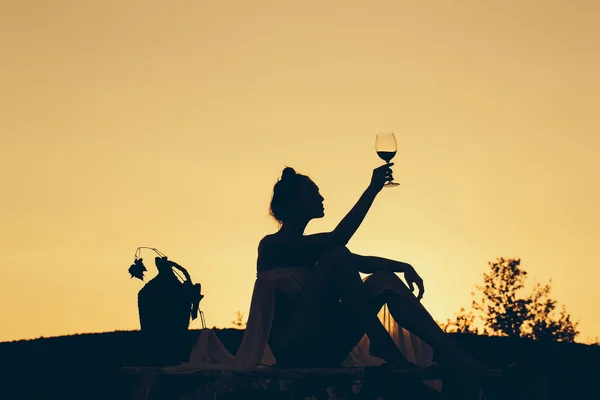 Silhouette eines Mädchens mit Wein — Stockfoto