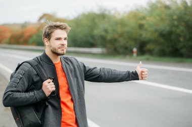 Genç adam otostop çekiyor.
