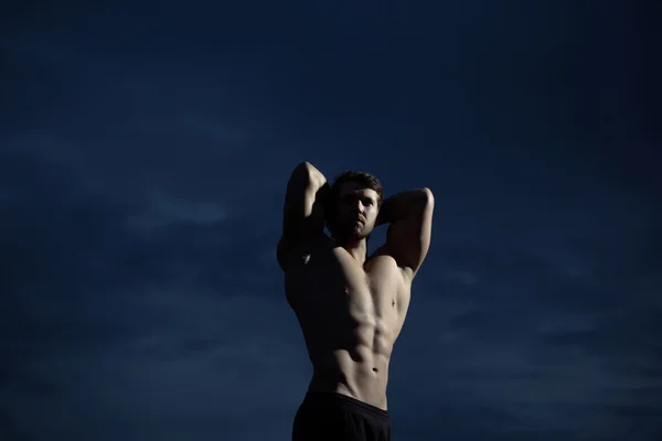 Sexy muscular macho hombre en azul cielo — Foto de Stock
