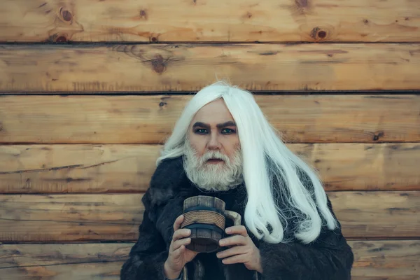 Uomo barbuto con tazza di legno — Foto Stock