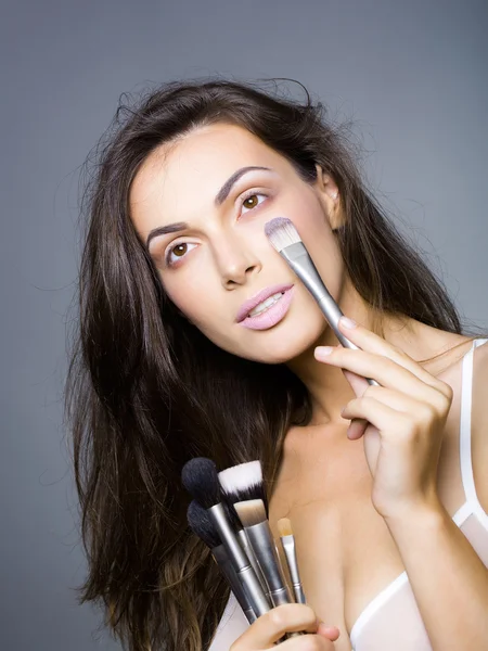 Mooie vrouw in beha met make-up borstel — Stockfoto