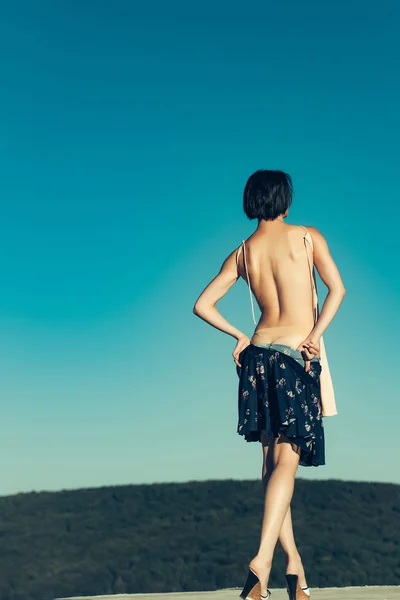 Mujer joven desnudándose en el cielo azul —  Fotos de Stock