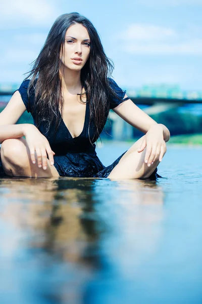 Молодая сексуальная женщина, сидящая в воде — стоковое фото