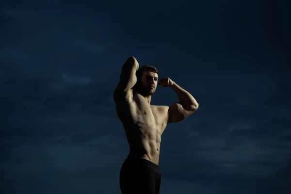 Sexy muskulöser Macho-Mann am blauen Himmel — Stockfoto